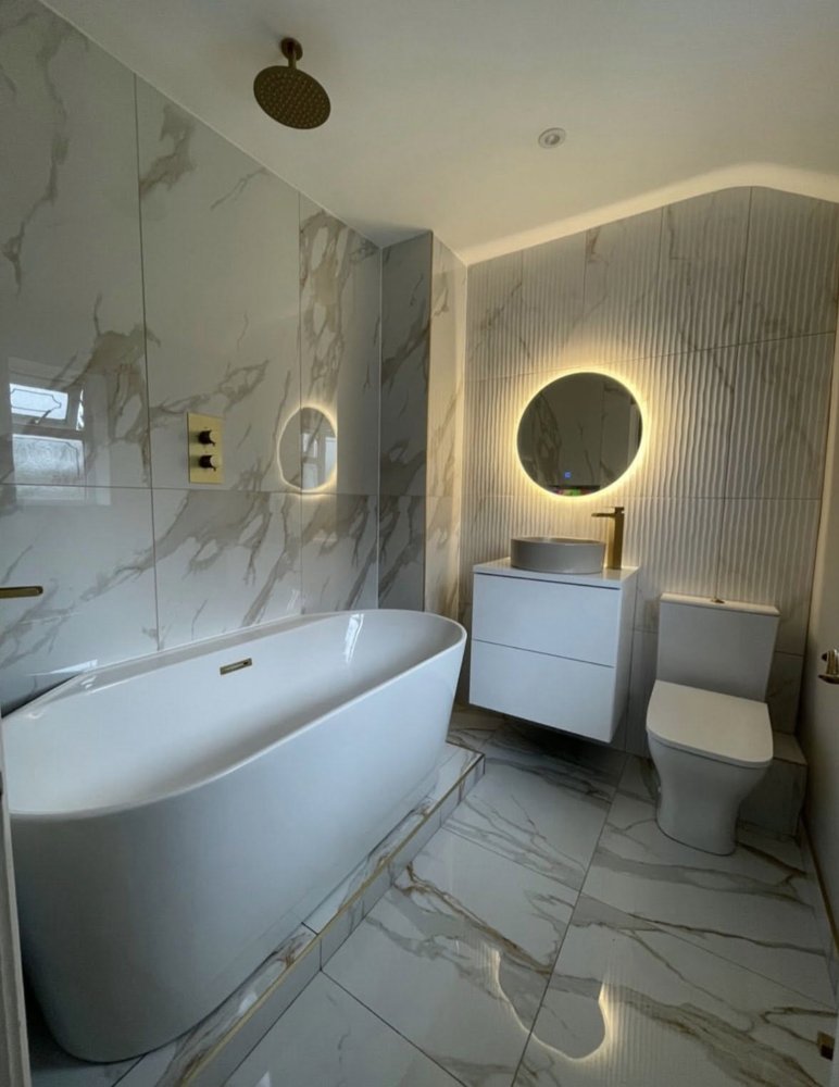 Marble-effect bathroom with freestanding bath and brushed gold fittings