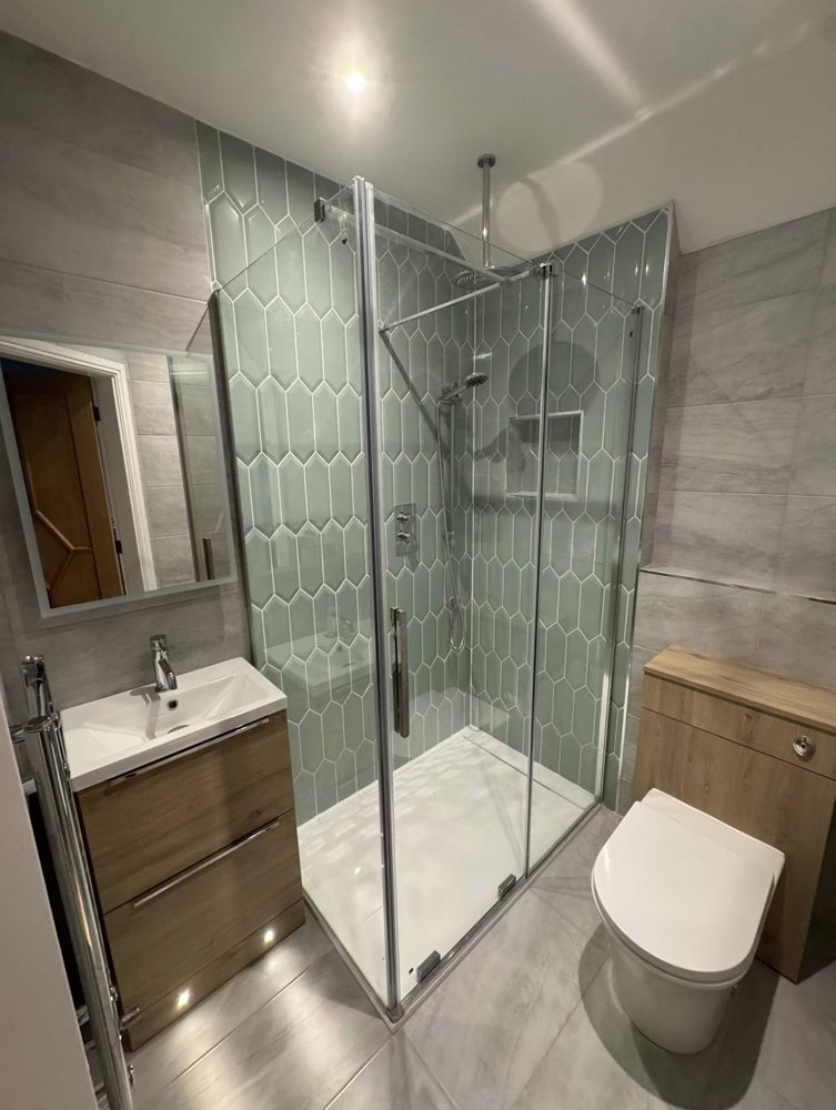 Shower room with sage green hexagon tiles and a wood-effect vanity unit