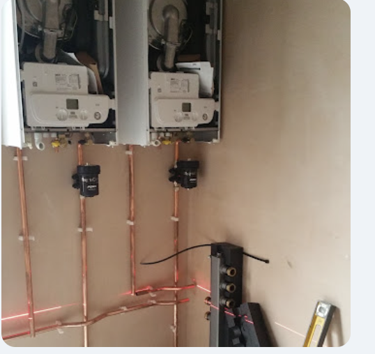 Two new boilers being installed, with copper pipework set out using a laser level